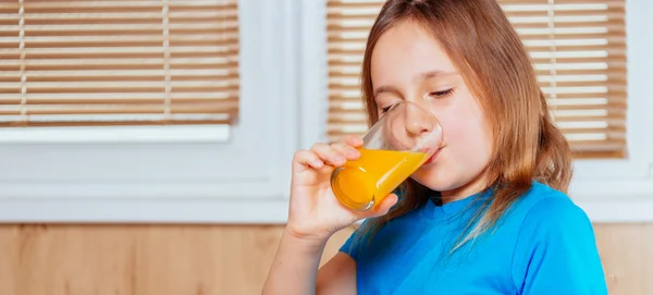 Kid drinks orange juice — Stock Photo, Image