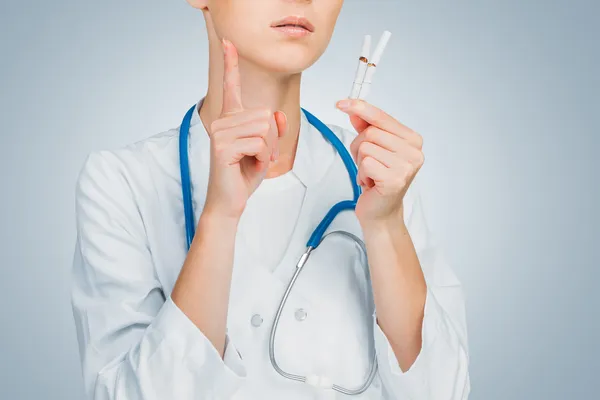 Le médecin tient une cigarette cassée — Photo