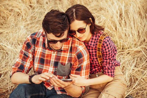 Mladý pár, sledovat mobilní telefon — Stock fotografie