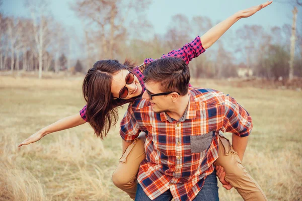 Man holds woman on his back — Stock Photo, Image