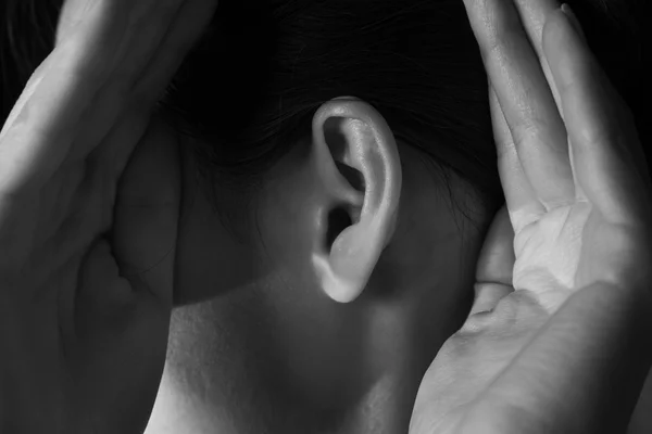 Vrouw houdt haar handen in de buurt van oor — Stockfoto