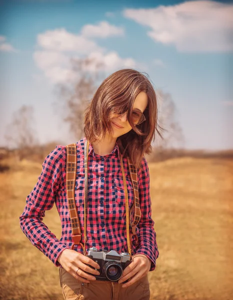 Woman holds old photo camera on nature — Stock Photo, Image