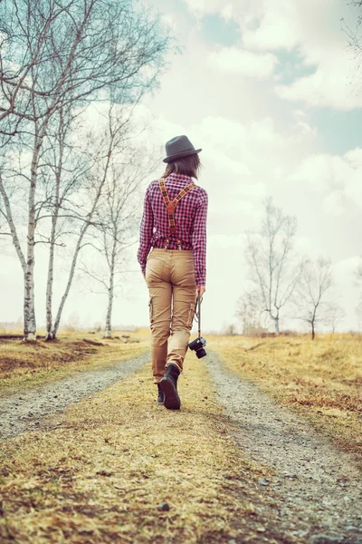 Mulher caminha em uma estrada — Fotografia de Stock