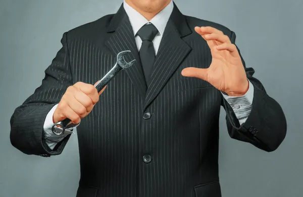 Businessman with metal wrench — Stock Photo, Image