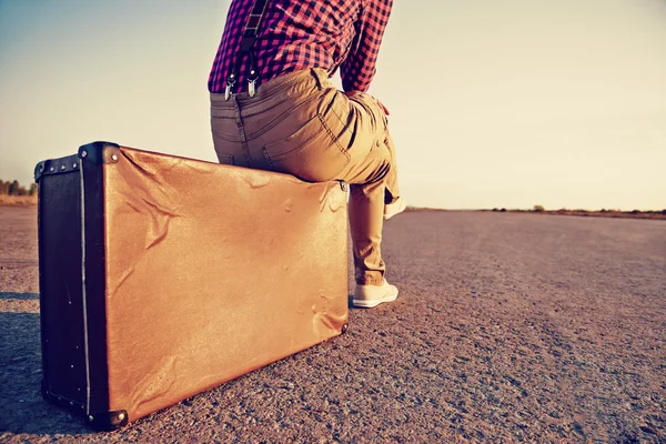 Traveler sits on suitcase — Stock Photo, Image