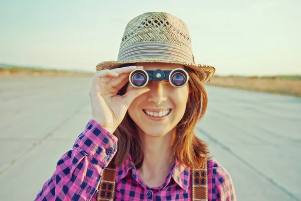 Girl looks through binoculars — Stock Photo, Image