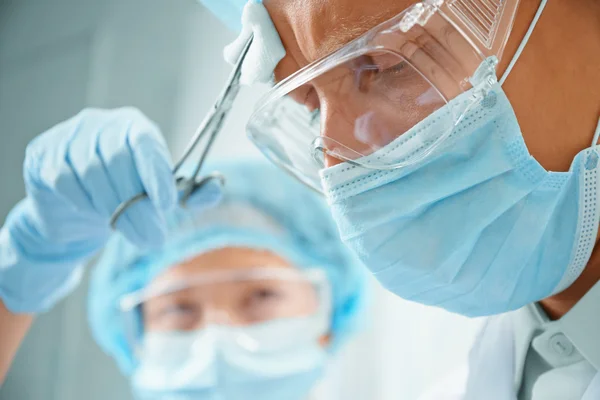 Assistant rubs forehead of man surgeon — Stock Photo, Image