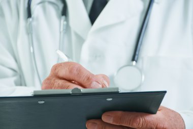 yaşlı doktor tıbbi notlar yazıyor