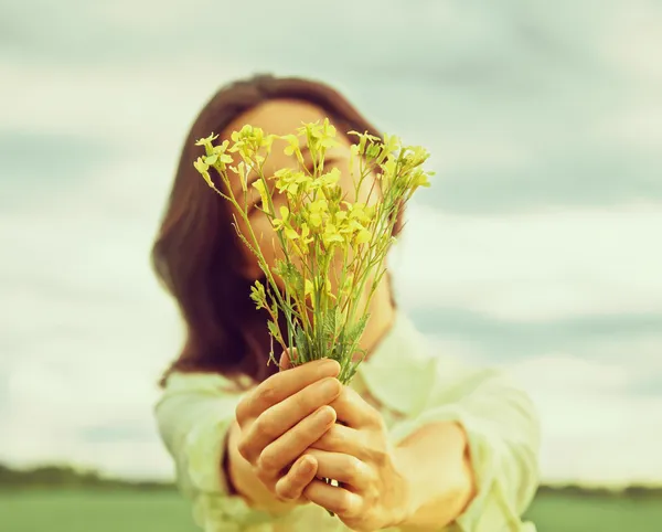 Femme tient bouquet de fleurs — Photo
