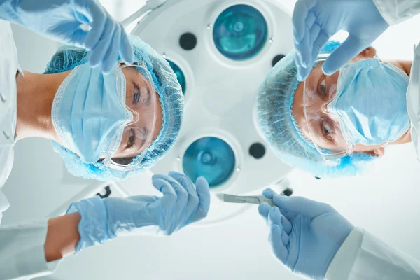 Sjuksköterskeassistenter passerar en skalpell till kirurgen — Stockfoto
