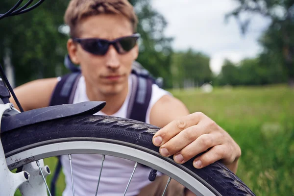 Велосипедист перевіряє колесо — стокове фото