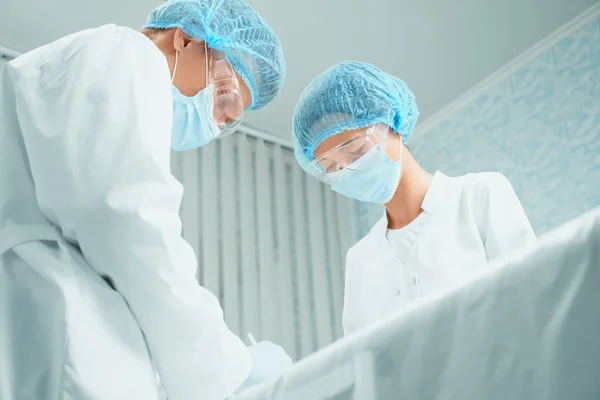Two surgeons in operating room — Stock Photo, Image