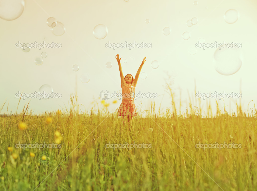 Happy girl among soap bubbles