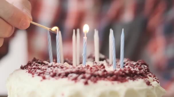 알아볼 수없는 남자가 생일 케이크에 촛불을 밝힌다. — 비디오