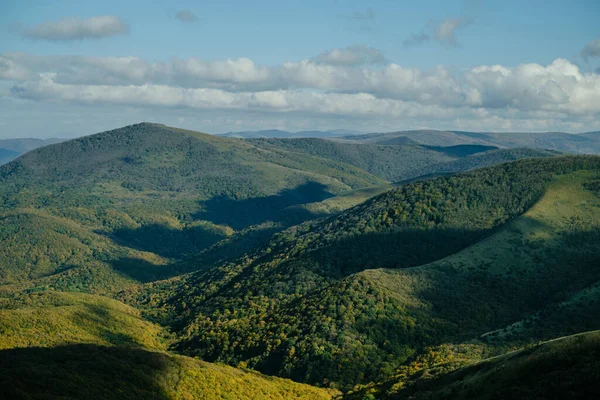 Paisagem montanhosa com colinas verdes e céu azul. — Fotografia de Stock