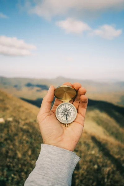 Kompas v ruce v pozadí horské krajiny. — Stock fotografie