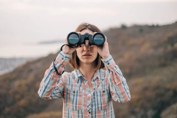Beautiful woman with binoculars looks into the camera. — Stock Photo, Image