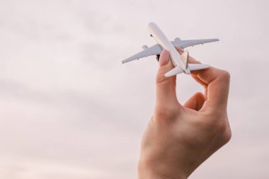 Hayalperest elinde arka planda oyuncak model bir uçak tutuyor..