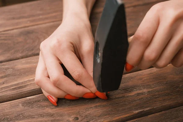 Primer plano de las manos femeninas con una manicura con un martillo en las manos. — Foto de Stock