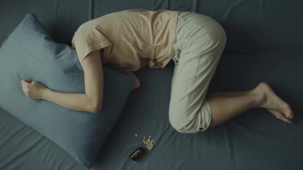Une jeune femme s'allonge sur le lit la tête sous l'oreiller. — Video