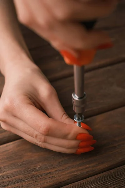Primer plano de las manos femeninas con una manicura con un destornillador en las manos. — Foto de Stock