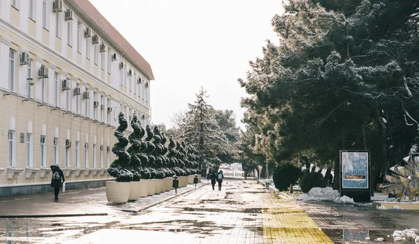 Paesaggio urbano con persone che camminano lungo il terrapieno accanto alla città Amministrazione nella stagione invernale. Foto Stock