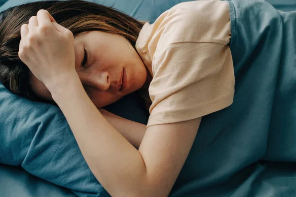 Сумна молода жінка лежить в ліжку з депресивним станом . — стокове фото