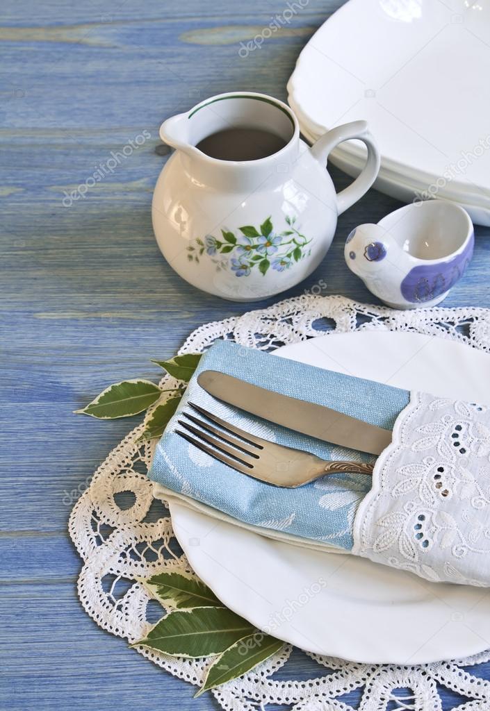 Vintage table setting with leaves decorations, napkins on a blue