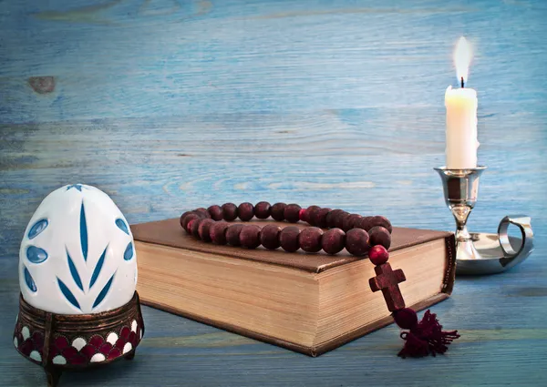 Easter egg in a stand, the Bible and candle — Stock Photo, Image