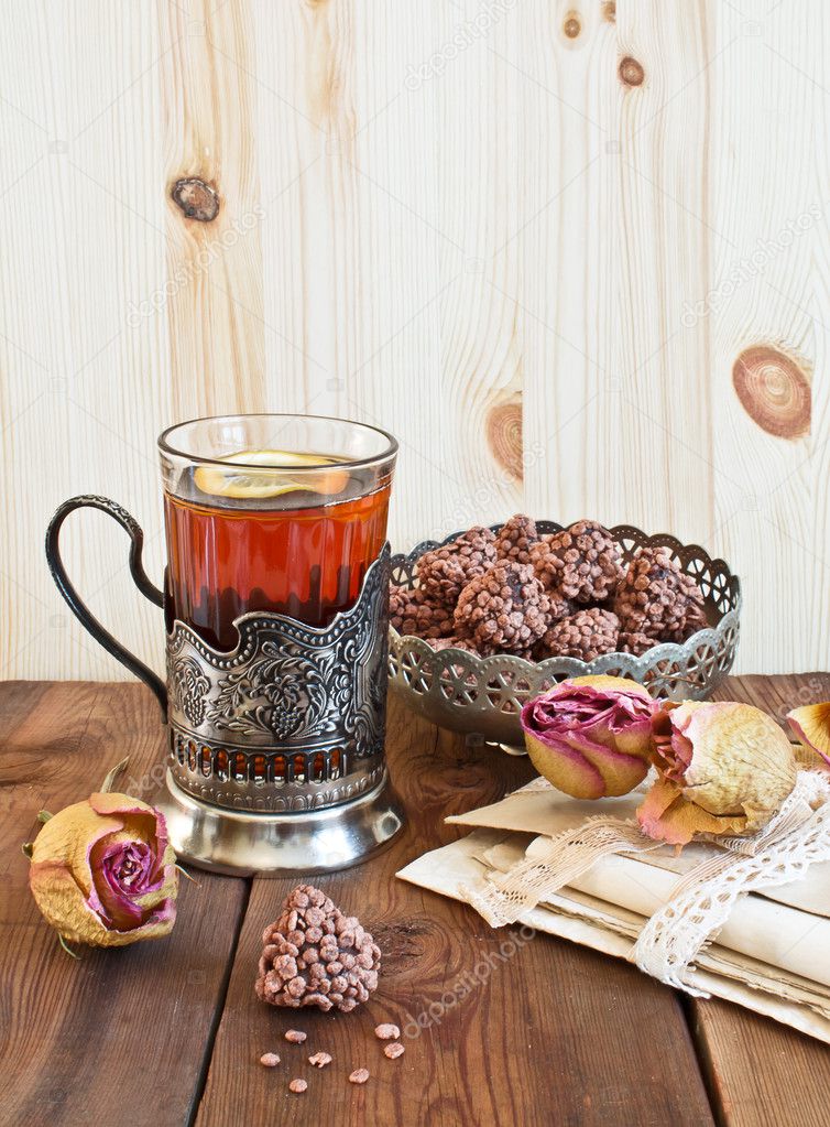 Tea with lemon in the glass-holder and old letters