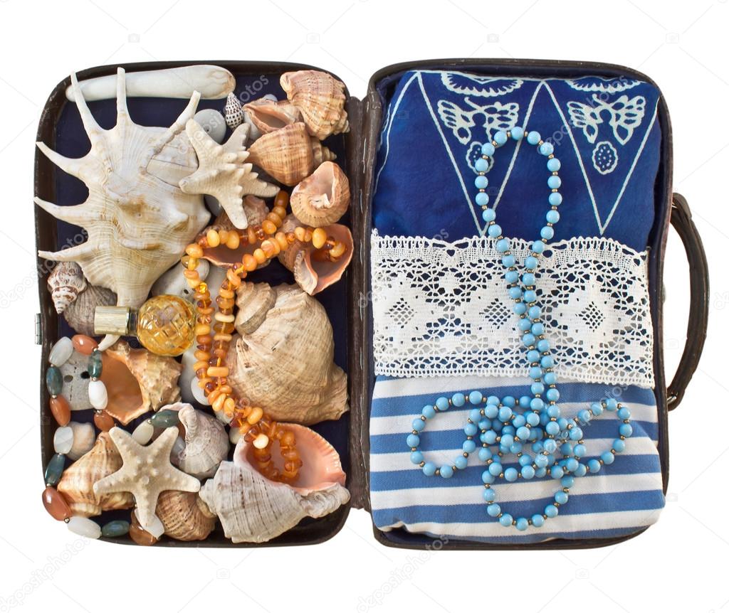 Open road suitcase with clothes and shells