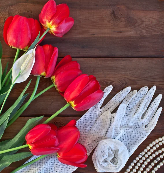 Red tulips and white lace gloves on wooden background — Stock Image Red tulips and white lace gloves on wooden background Royalty Free Stock Images