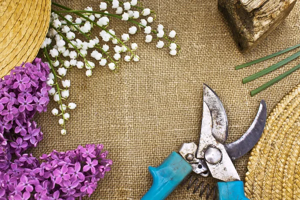 Lilac, lily of the valley and secateurs on a canvas background. — Stock Photo, Image