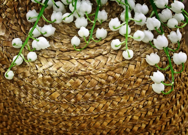 Sombrero de paja con un lirio del valle — Foto de Stock