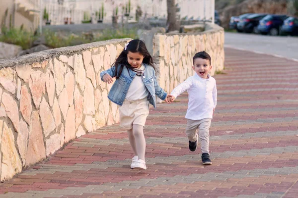 Bruder und Schwester laufen Hand in Hand. — Stockfoto