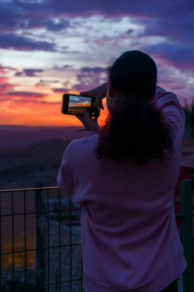Visszapillantás fiatal nő csinál egy képet a csodálatos naplemente. — Stock Fotó