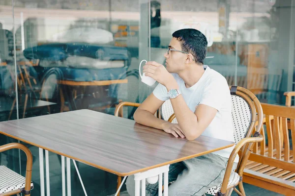 Підліток у кафе з чашечкою кави, глибокі думки. — стокове фото