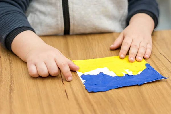 Дитина вивішує з пластику український прапор.. — стокове фото