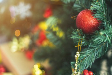 Mutlu Noel 'ler, renkli baloları, hediye kutularını ve Noel arkaplanındaki yeşil Noel ağacı dekorasyonunu Noel ve yeni yıl boyunca kutlayın..