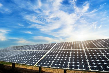 Fotovoltaik güneş enerjisi paneli dramatik gün batımı mavi gökyüzü arkaplanı, yeşil temiz Alternatif enerji kavramı.