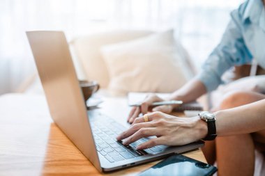 Bilgisayarla çalışan serbest çalışan iş kadınlarının el yazısını yakın plan çekimleri ve not defterine yazılı notlar almak, kahve dükkanındaki ılık süt bardağı, mesela uzaktan iletişim konsepti.