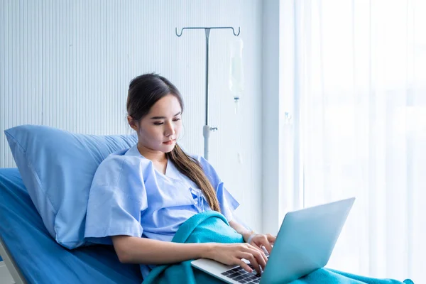 아시아인젊은 여성웃는 병실의 배경에서 컴퓨터로 일하는 시간에 일하는 — 스톡 사진