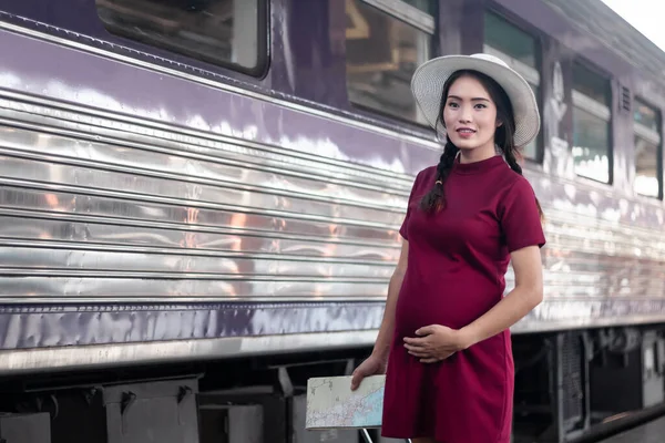 赤いドレスを着たアジアの女性は 鉄道駅の旅行で赤いスーツケースで地図を保持し 夏の休暇のコンセプトでバックパックを持つ旅行者タイ — ストック写真