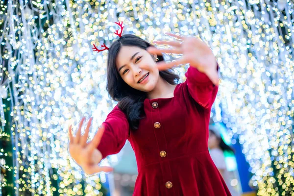 아름다운 아시아인 여성붉은 드레스와 크리스마스 인사말 크리스마스 트리등 반원보케 성탄절 — 스톡 사진