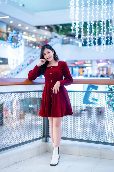 아름다운 아시아인 여성붉은 드레스와 크리스마스 인사말 크리스마스 트리등 반원보케 성탄절 — 스톡 사진