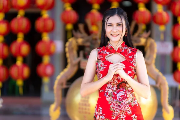 肖像画美しい笑顔アジアの若い女性は タイの中国の神社で中国の旧正月祭りのための赤いChongsamドレス伝統的な装飾を身に着けている中国の文化を祝う — ストック写真