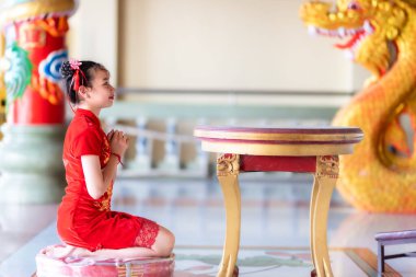Güzel, küçük, şirin, Asyalı, geleneksel Çin nişanı takan genç bir kadın. Tayland 'daki Çin tapınağında yapılacak Çin Yeni Yıl Festivali için Buda heykeline dua edin.