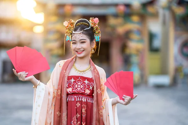アジアの幸せの美しさ中国の古代の衣装を着て女の子は 中国の旧正月の祭りのための赤い封筒の装飾を保持タイの中国の神社公共の場所で中国の文化を祝う — ストック写真