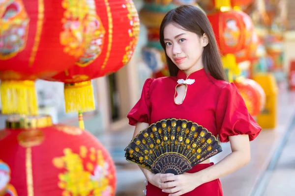 中国語のアルファベットが書かれた紙の提灯で赤い伝統的な中国のチョンサムの装飾を身に着けているアジアの女性それに書かれた祝福は中国の旧正月のための幸運祝福の装飾です — ストック写真