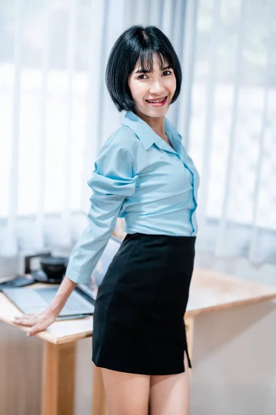 ポートレートアジア人フリーランスの歯ブラシで笑顔ビジネス女性コーヒーショップのカフェのインテリアに青いシャツを着て ビジネスライフスタイルのコンセプト — ストック写真